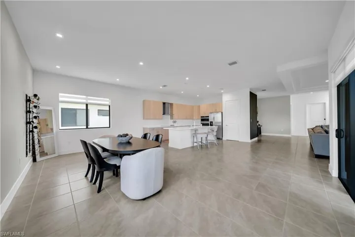 Dining space with light tile patterned floors and recessed lighting