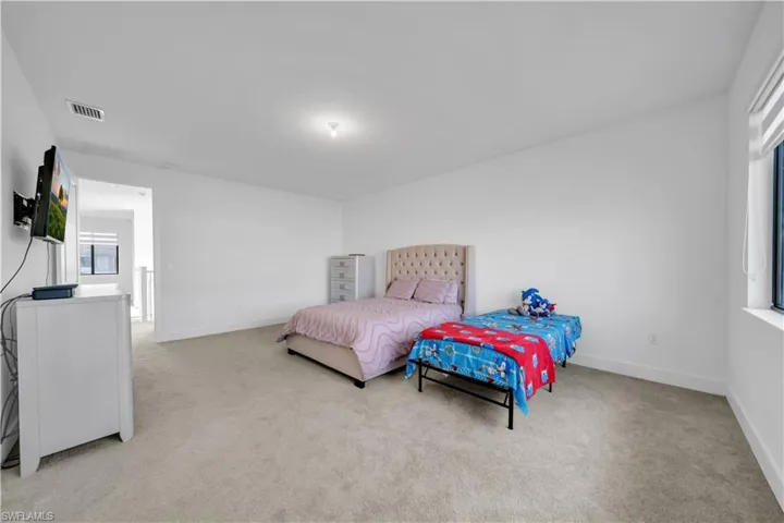 Bedroom featuring light carpet