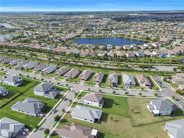 Aerial view of property and surrounding area featuring a large body of water and nearby suburban area