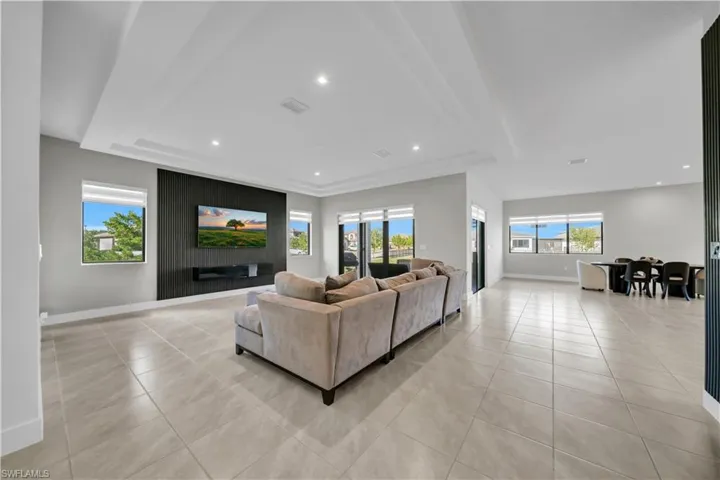 Living area with light tile patterned floors and recessed lighting