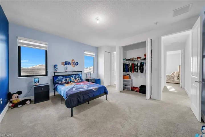 Bedroom featuring a textured ceiling, carpet, and a closet