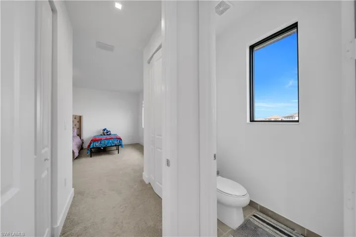 Bathroom featuring light colored carpet and ensuite bath