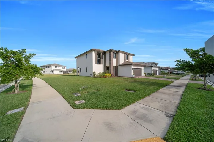 View of property's community featuring a yard, a garage, and a residential view