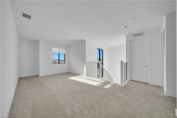 Spare room with light carpet and baseboards