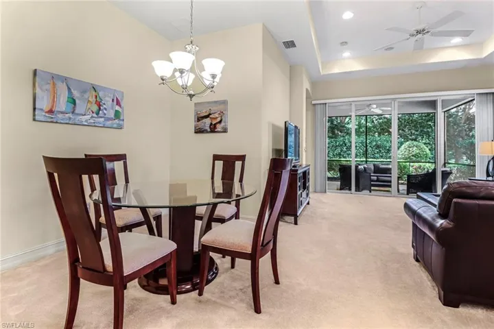 Dining Room features a high ceiling, ceiling fan with notable chandelier, and a tray ceiling