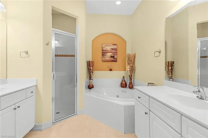 Bathroom with tile flooring, shower with separate bathtub, and vanity