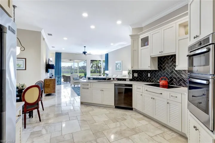 Kitchen featuring sink, tasteful backsplash, crown molding, white cabinets, and appliances with stainless steel finishes