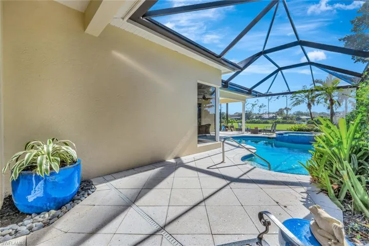 View of swimming pool with glass enclosure, ceiling fan, and a patio