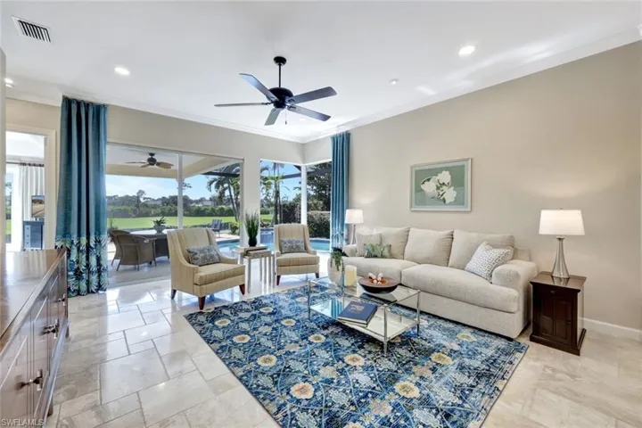 Living room with ceiling fan and crown molding