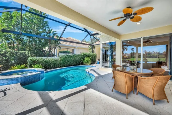 View of pool featuring a lanai, a patio area, an in ground hot tub, and ceiling fan