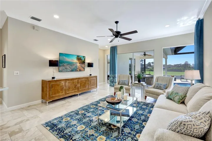 Living room featuring ceiling fan and ornamental molding
