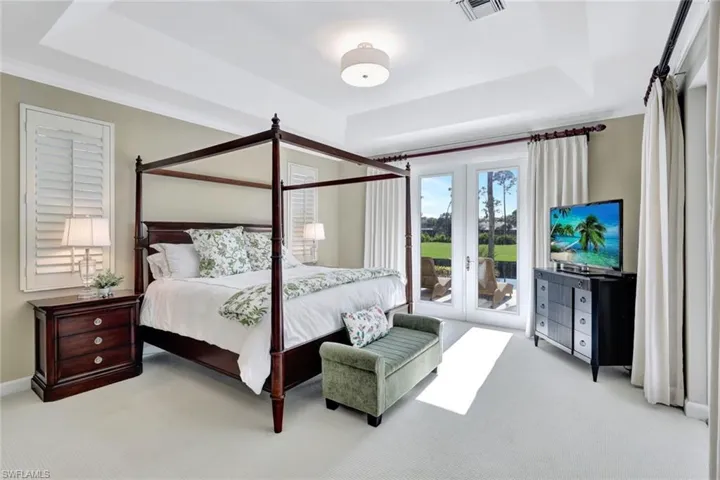 Gorgeous Master bedroom with  lake and golf views and french doors to pavered sun deck