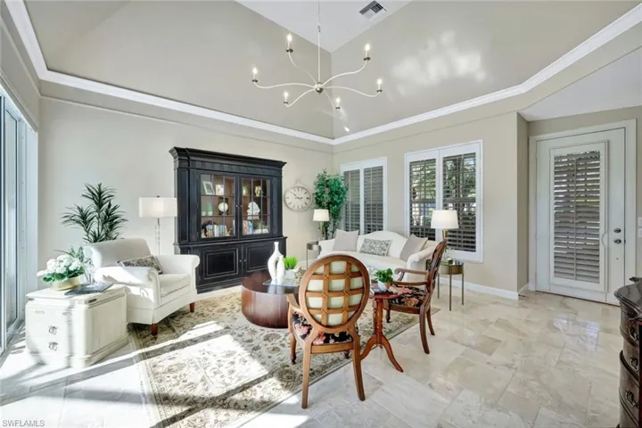 Living room with an inviting chandelier and ornamental molding