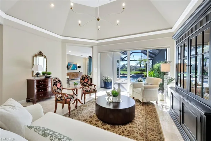 Tiled living room with ceiling fan and high vaulted ceiling