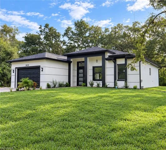 Modern architectural home featuring a clean-lined exterior with horizontal siding, dark-framed windows, and a contemporary flat roof