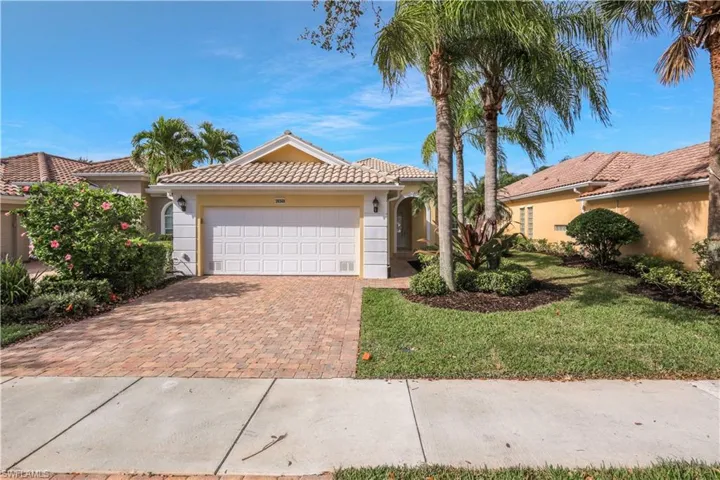 Mediterranean / spanish-style home with a tile roof, a front lawn, decorative driveway, stucco siding, and a garage