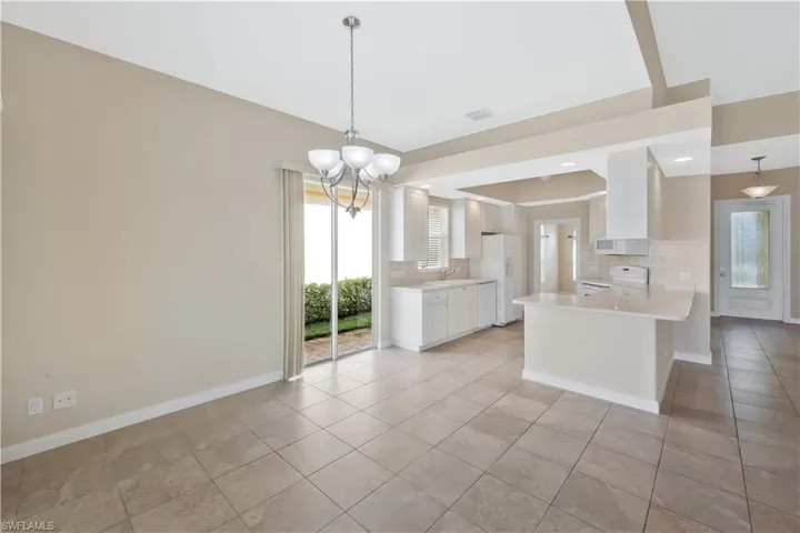 Kitchen featuring white cabinetry, light countertops, a chandelier, decorative backsplash, and recessed lighting