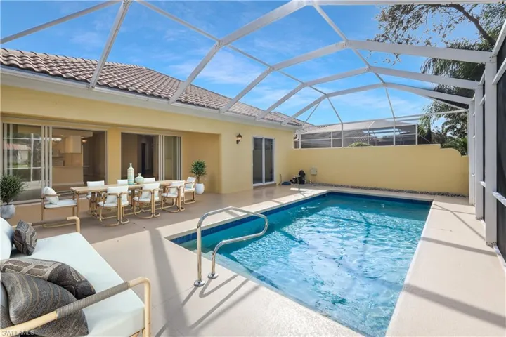 Swimming pool featuring a sunroom, a patio, a lanai, and outdoor dining space