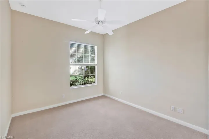 Empty room featuring carpet flooring and a ceiling fan
