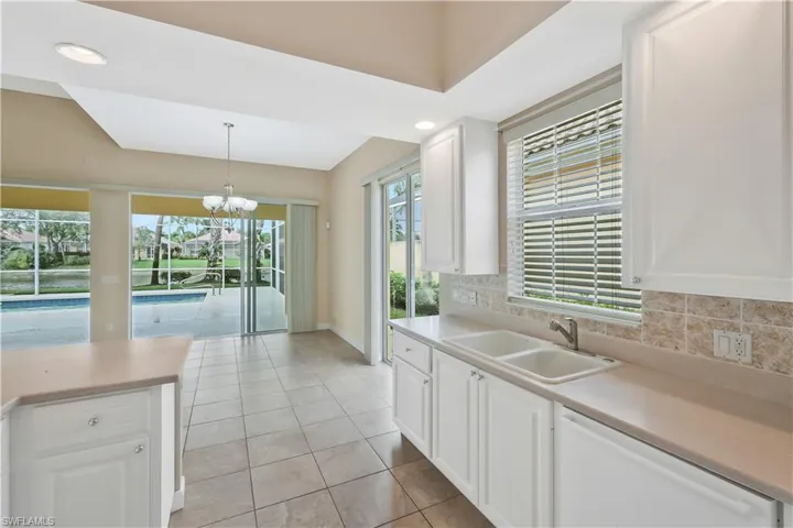 Kitchen with backsplash, white cabinetry, dishwasher, light tile patterned floors, and light countertops