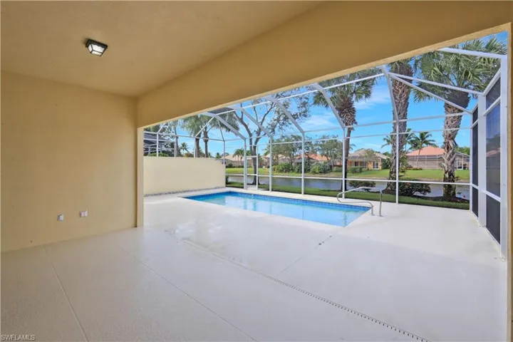 Swimming pool with a patio, a sunroom, a water view, and glass enclosure