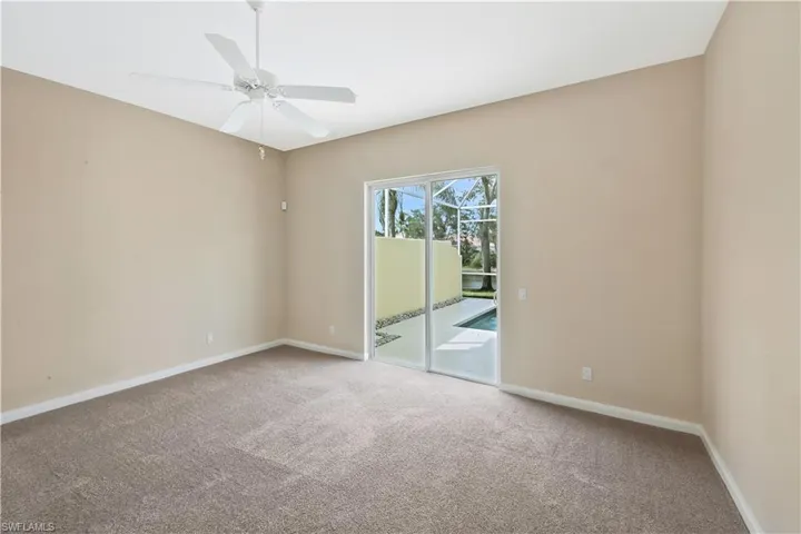 Carpeted spare room with baseboards and ceiling fan