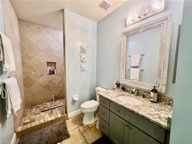 Primary bathroom with travertine stone tile shower.