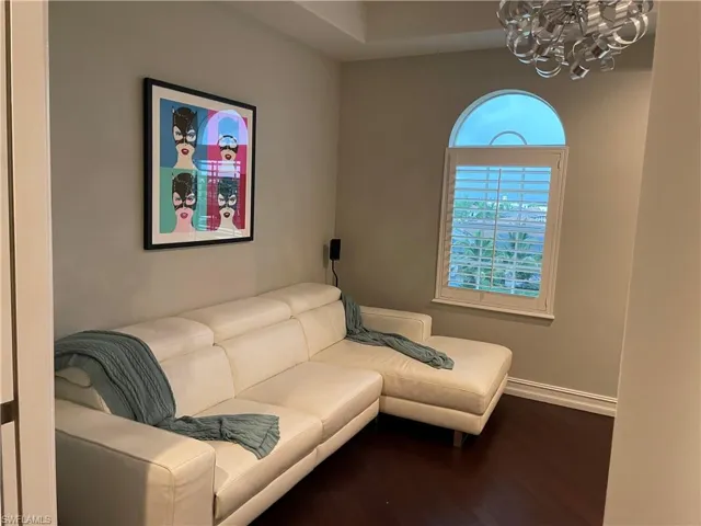 Living room featuring dark hardwood / wood-style flooring and an inviting chandelier
