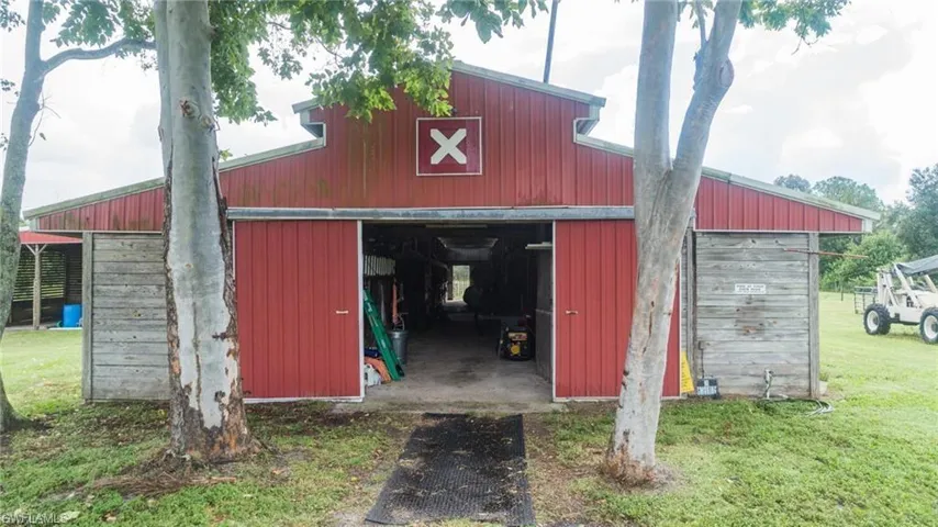 View of pole building featuring a yard and a barn