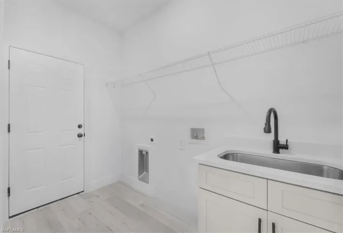 Interior utility room leads to garage and includes a utility sink.