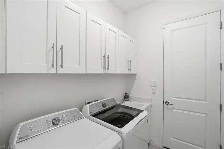 Washroom with washing machine and dryer and cabinet space
