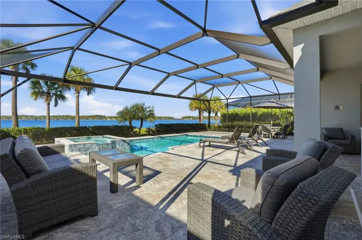 View of swimming pool with a patio, a lanai, a sunroom, a pool with connected hot tub, and a water view