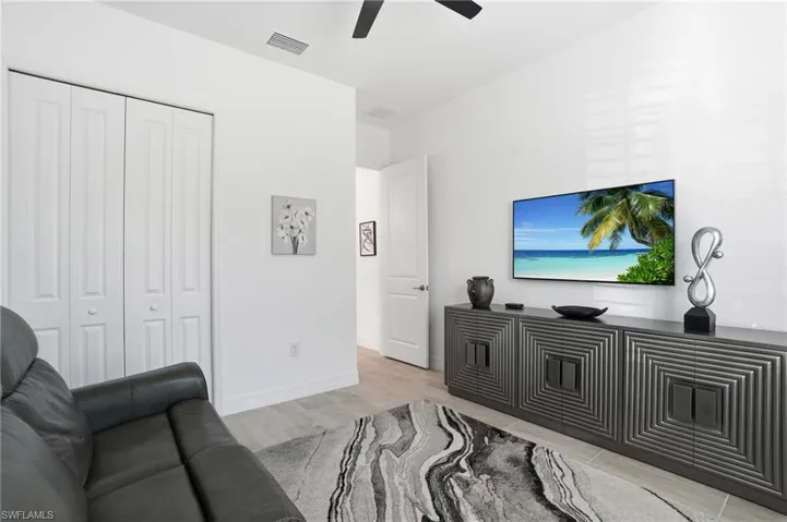 Living area featuring baseboards and ceiling fan