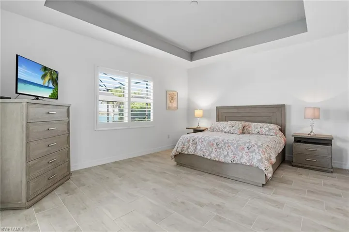 Bedroom featuring a raised ceiling and wood finish floors