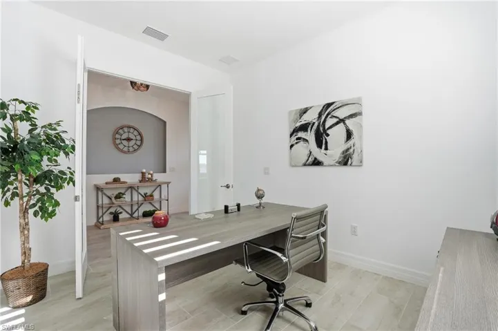 Office space with light wood-style flooring and baseboards