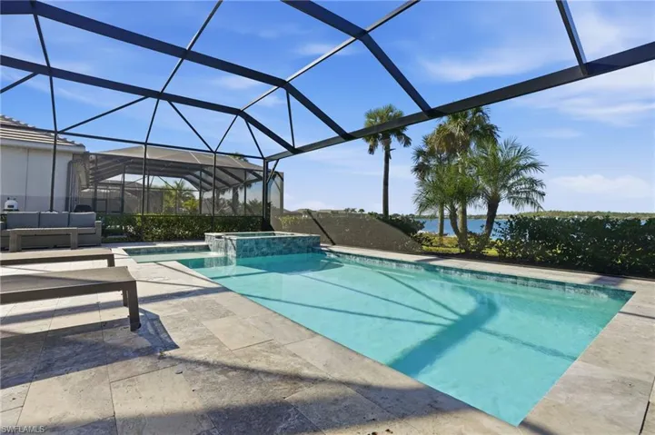 View of swimming pool featuring a sunroom, a lanai, a pool with connected hot tub, and a patio area
