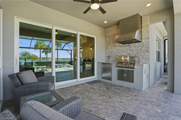 View of patio / terrace with area for grilling, a water view, and a ceiling fan