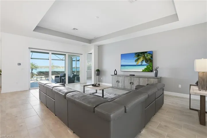 Living area featuring a raised ceiling and baseboards