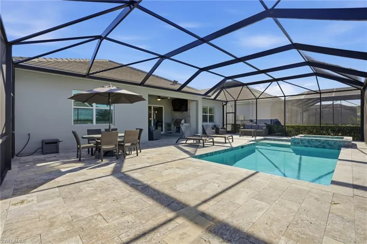 View of swimming pool featuring a sunroom, glass enclosure, a pool with connected hot tub, a patio area, and a ceiling fan