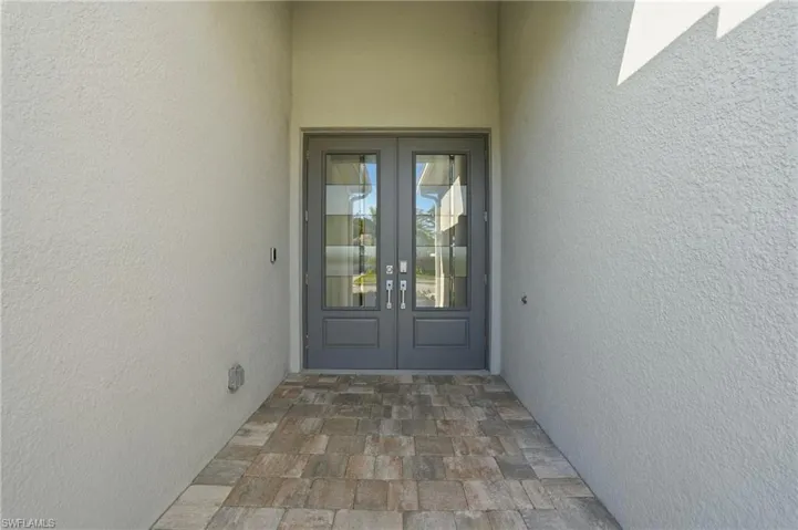 Entrance to property featuring french doors and stucco siding