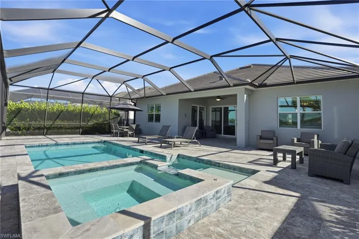 View of pool featuring a sunroom, a patio area, a pool with connected hot tub, a lanai, and ceiling fan