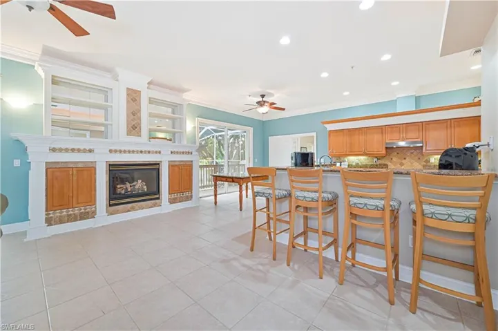 Kitchen with ceiling fan, ornamental molding, under cabinet range hood, tasteful backsplash, and recessed lighting