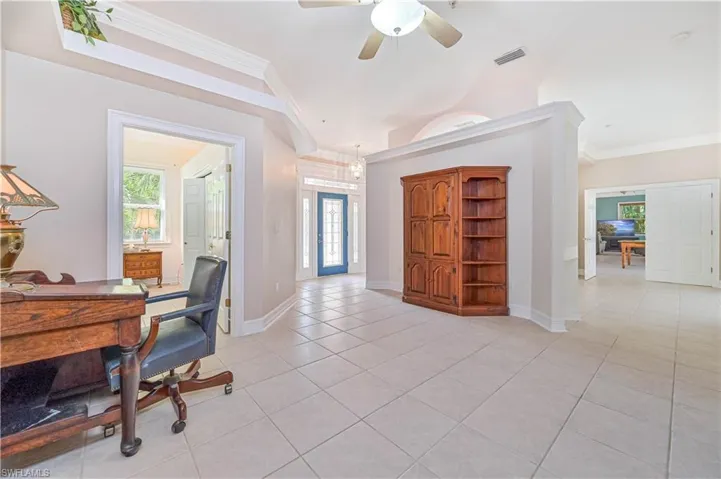 Office space featuring light tile patterned floors, crown molding, and ceiling fan
