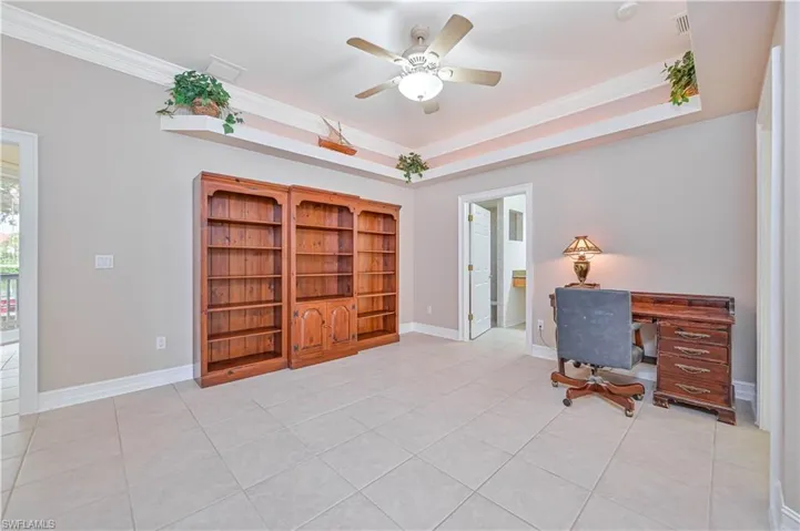 Office space featuring crown molding, a ceiling fan, and light tile patterned floors