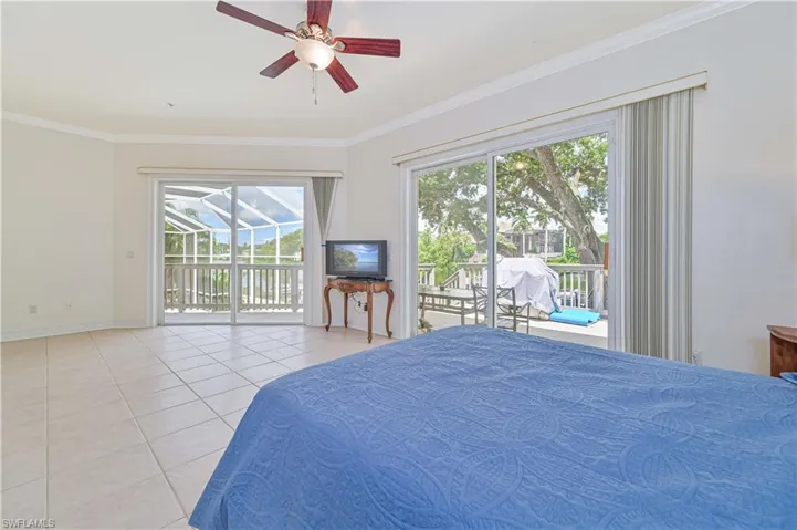 Bedroom with tile patterned floors, access to exterior, ornamental molding, and ceiling fan