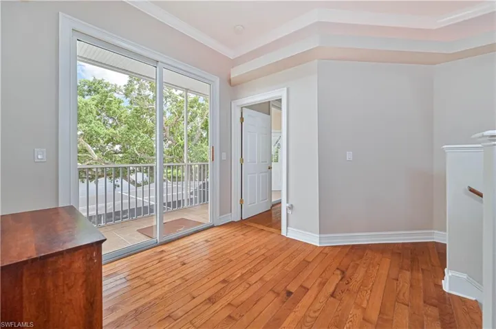 Spare room featuring hardwood / wood-style floors and crown molding