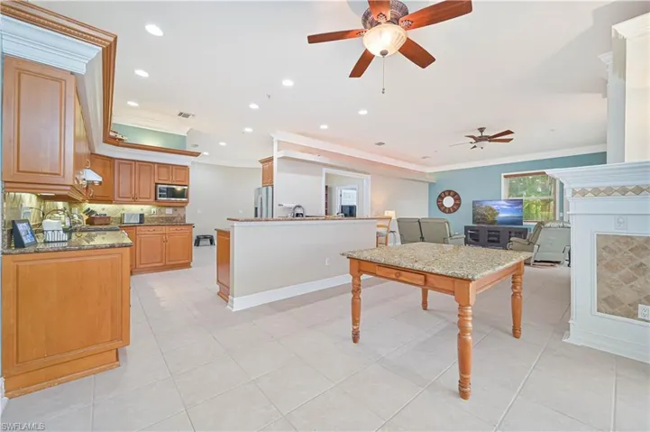 Kitchen with stainless steel appliances, crown molding, ceiling fan, decorative backsplash, and recessed lighting