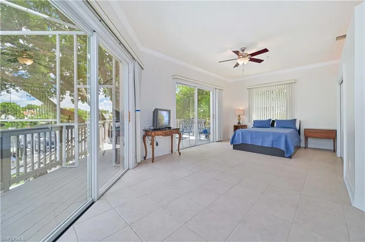 Bedroom featuring access to outside, light tile patterned floors, crown molding, and ceiling fan