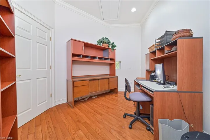 Home office with crown molding, light wood-style flooring, attic access, and recessed lighting