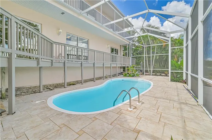 Outdoor pool featuring a patio area and glass enclosure